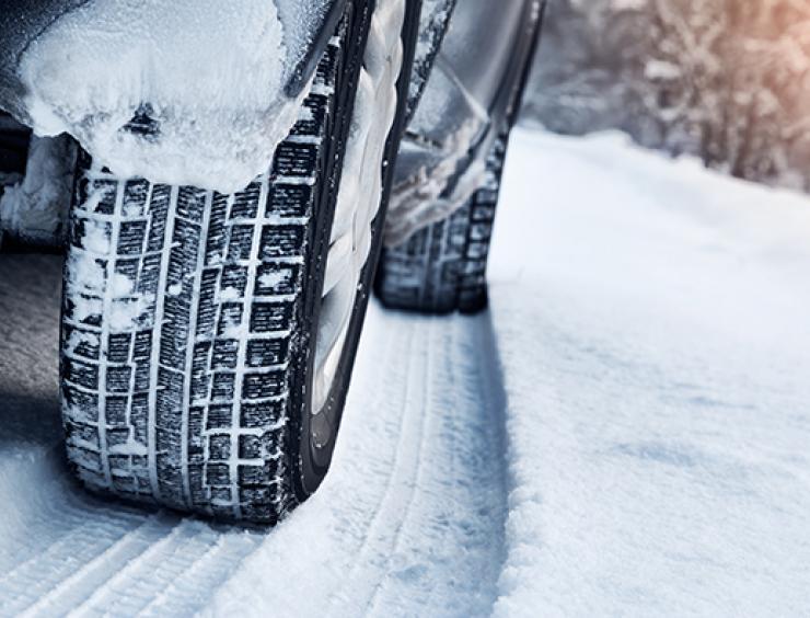 le pneu enneigé d'une voiture sur une route enneigée