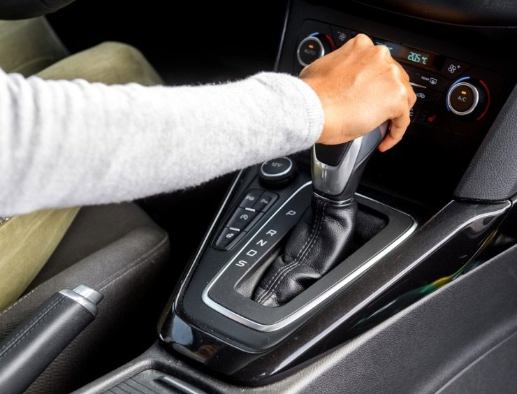une personne tient le levier de vitesse d'une voiture
