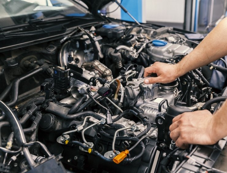 un homme travaillant sur un moteur de voiture dans un garage
