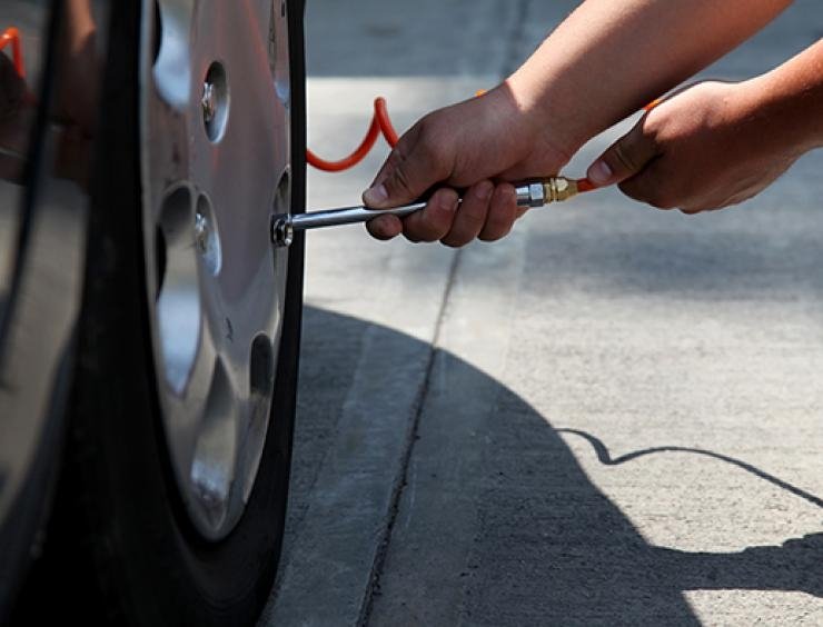 un homme change le pneu d'une voiture