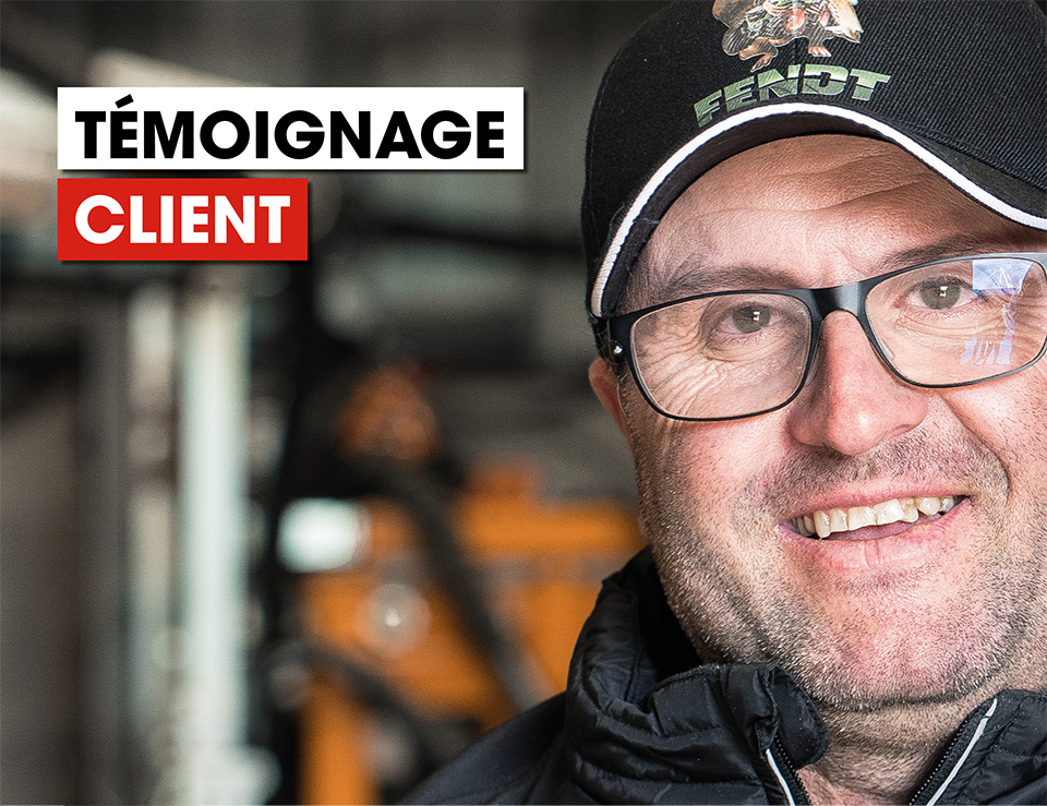 un homme portant des lunettes et un chapeau sourit pour la caméra