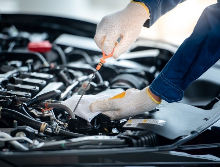 un homme travaillant sur un moteur de voiture