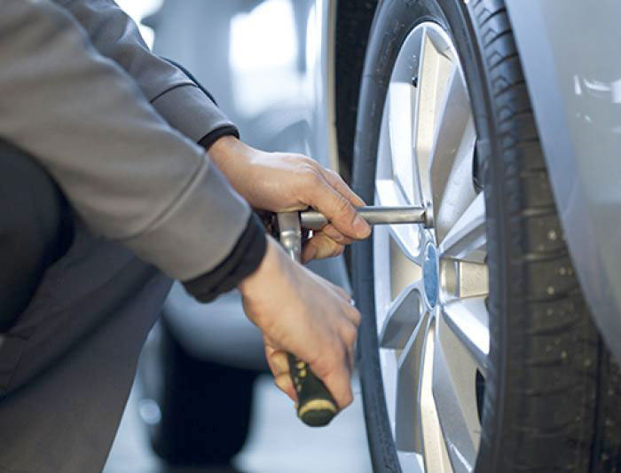 une personne qui change un pneu sur une voiture