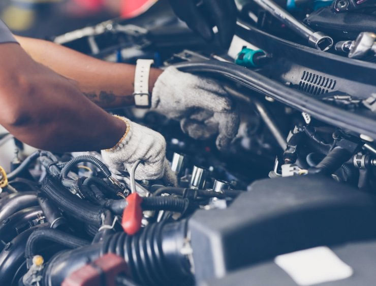 un homme travaillant sur un moteur de voiture